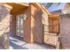 Close up of the front entrance with a brick column, a black metal gate, and a glass paneled door at 437 Via Stretto Ave, Henderson, NV 89011
