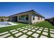 Expansive backyard with lush synthetic grass, stone path, and modern home exterior at 47 Garibaldi Way, Henderson, NV 89011