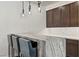 Modern bar area with sleek marble countertops and dark wood cabinets at 47 Garibaldi Way, Henderson, NV 89011