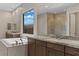 A luxurious bathroom showcasing a soaking tub, walk-in shower, and dual vanity sinks at 47 Garibaldi Way, Henderson, NV 89011