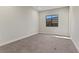 Bright bedroom features neutral carpet, a large window with a view, and fresh paint at 47 Garibaldi Way, Henderson, NV 89011