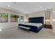 A bedroom featuring a plush, tufted blue bed frame, complemented by elegant mirrored sconces at 47 Garibaldi Way, Henderson, NV 89011