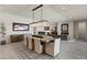 Open concept living space with modern dining area, chandelier, and gray couches and fireplace at 47 Garibaldi Way, Henderson, NV 89011