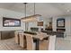Open concept living space with modern dining area, chandelier, and gray couches and fireplace at 47 Garibaldi Way, Henderson, NV 89011