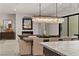 Open concept living space with modern dining area, chandelier, and gray couches and fireplace at 47 Garibaldi Way, Henderson, NV 89011