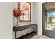 Charming entryway with a wooden console table, vibrant floral arrangement, and artwork at 47 Garibaldi Way, Henderson, NV 89011