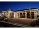 Striking home exterior featuring a stone facade and modern glass garage doors at twilight at 47 Garibaldi Way, Henderson, NV 89011
