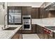 Gourmet kitchen features stainless steel appliances, custom cabinets, stylish backsplash, and marble countertops at 47 Garibaldi Way, Henderson, NV 89011