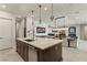 Gourmet kitchen features stainless steel appliances, custom cabinets, stylish lighting, and marble countertops at 47 Garibaldi Way, Henderson, NV 89011
