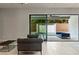 Modern living room with sliding glass doors to a patio featuring stylish outdoor furniture at 47 Garibaldi Way, Henderson, NV 89011