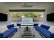 Stylish covered patio with blue sofas, TV, and water feature in the backyard at 47 Garibaldi Way, Henderson, NV 89011