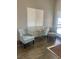 Bright living area featuring wood-look tile floors, two comfy chairs and a window with white blinds at 4704 Obannon Dr # D, Las Vegas, NV 89102