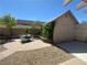 Backyard featuring a tan outbuilding, a tan block wall, a small tree, a patio and a table with four chairs at 511 Credence Ave, Henderson, NV 89002