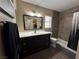 Well lit bathroom featuring a dark wood vanity, shower and toilet in a neutral color palette at 511 Credence Ave, Henderson, NV 89002