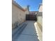 Side of house view with long driveway leading to gate access to back yard and tan stucco exterior at 511 Credence Ave, Henderson, NV 89002
