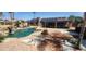 This backyard boasts a large pool with waterfall, fire pit, and lounge area with solar panels on the home at 5312 Manuel Dr, Las Vegas, NV 89149