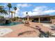 Beautiful backyard features a swimming pool with waterfall, fire pit, covered patio with sectional and mature landscaping at 5312 Manuel Dr, Las Vegas, NV 89149
