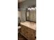 Bright bathroom featuring a vanity with a marble countertop, decorative mirror, and stylish lighting fixture at 5312 Manuel Dr, Las Vegas, NV 89149