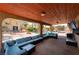 Covered patio offers a sectional sofa, ceiling and beautiful backyard views with mature landscaping, pool, and fire pit at 5312 Manuel Dr, Las Vegas, NV 89149