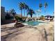 Backyard view with a pool, rock waterfall, fire pit, and palm trees, creating a relaxing atmosphere at 5312 Manuel Dr, Las Vegas, NV 89149