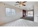 Living room featuring a ceiling fan, large windows, and access to the backyard at 5620 Pinecone Pl, Las Vegas, NV 89108