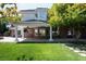 Backyard view of a two-story home featuring a covered patio and green lawn at 5860 N Campbell Rd, Las Vegas, NV 89149