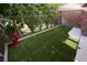 Backyard lawn with green artificial turf, fencing, and shade trees at 5860 N Campbell Rd, Las Vegas, NV 89149