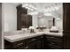 Bathroom vanity with dark wood cabinets, marble countertops, and ample lighting at 5860 N Campbell Rd, Las Vegas, NV 89149