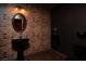 Stylish powder room with brick accent wall, modern fixtures, and dark wood floors at 5860 N Campbell Rd, Las Vegas, NV 89149