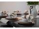 A dining table is set with plates, bowls, linen napkins, and wooden napkin rings at 5860 N Campbell Rd, Las Vegas, NV 89149