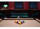 Close-up of billiards table with dark trim and cozy lounge area behind at 5860 N Campbell Rd, Las Vegas, NV 89149