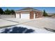 Detached two-car garage with a brick exterior and white doors, next to basketball court at 5860 N Campbell Rd, Las Vegas, NV 89149