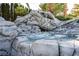 An artful rock formation provides a natural and luxurious setting for this backyard hot tub and waterfall feature at 5860 N Campbell Rd, Las Vegas, NV 89149