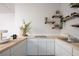 Bright kitchen featuring white cabinetry, countertops and floating shelves at 5860 N Campbell Rd, Las Vegas, NV 89149