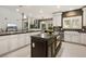 Bright kitchen with breakfast nook featuring white cabinets, stainless appliances, and stone accents at 5860 N Campbell Rd, Las Vegas, NV 89149