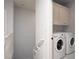 Convenient laundry area with a stacked washer and dryer unit, complemented by overhead cabinetry for storage at 5860 N Campbell Rd, Las Vegas, NV 89149