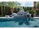 Beautiful pool with rock features and slide surrounded by palm trees at 5860 N Campbell Rd, Las Vegas, NV 89149
