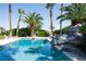 Luxurious pool area with tropical landscaping and rock waterfall feature at 5860 N Campbell Rd, Las Vegas, NV 89149