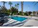 A luxurious pool with a diving board and a basketball hoop surrounded by lush landscaping and tall palm trees at 5860 N Campbell Rd, Las Vegas, NV 89149