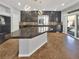 Spacious kitchen boasts dark cabinets, a contrasting countertop, and an island with pendant lighting at 6053 Lambert Bridge Ave, Las Vegas, NV 89139