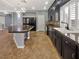 Spacious kitchen featuring an island with a marble countertop, dark wood cabinets, and stainless steel appliances at 6053 Lambert Bridge Ave, Las Vegas, NV 89139