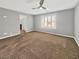 Large main bedroom with carpeted floors, a ceiling fan, neutral paint, and bright natural light from the shutter blinds at 6053 Lambert Bridge Ave, Las Vegas, NV 89139
