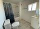 Bathroom featuring a tub with shower and a toilet with tiled floors and a window at 641 West St, Pahrump, NV 89048