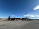 Wide shot of a brown single story exterior with a blue sky and clouds overhead at 641 West St, Pahrump, NV 89048