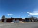 The exterior shows a red building with multiple doors, set against a clear blue sky and sparse vegetation at 641 West St, Pahrump, NV 89048