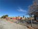 View of an exterior with a fenced-in yard, gravel, and bright, blue sky at 641 West St, Pahrump, NV 89048