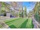 Backyard featuring artificial turf, mature trees, and privacy landscaping at 65 Pangloss St, Henderson, NV 89002