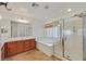 Bright bathroom featuring a soaking tub, shower, wood cabinets, and a large vanity mirror at 65 Pangloss St, Henderson, NV 89002
