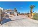 A sturdy metal gate and walls welcome visitors to the residence, with desert landscaping and mature trees at 6882 Palmyra Ave, Las Vegas, NV 89146