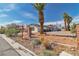 This desert-landscaped home with solar panels is enhanced by a circular driveway and mature palm trees at 6882 Palmyra Ave, Las Vegas, NV 89146
